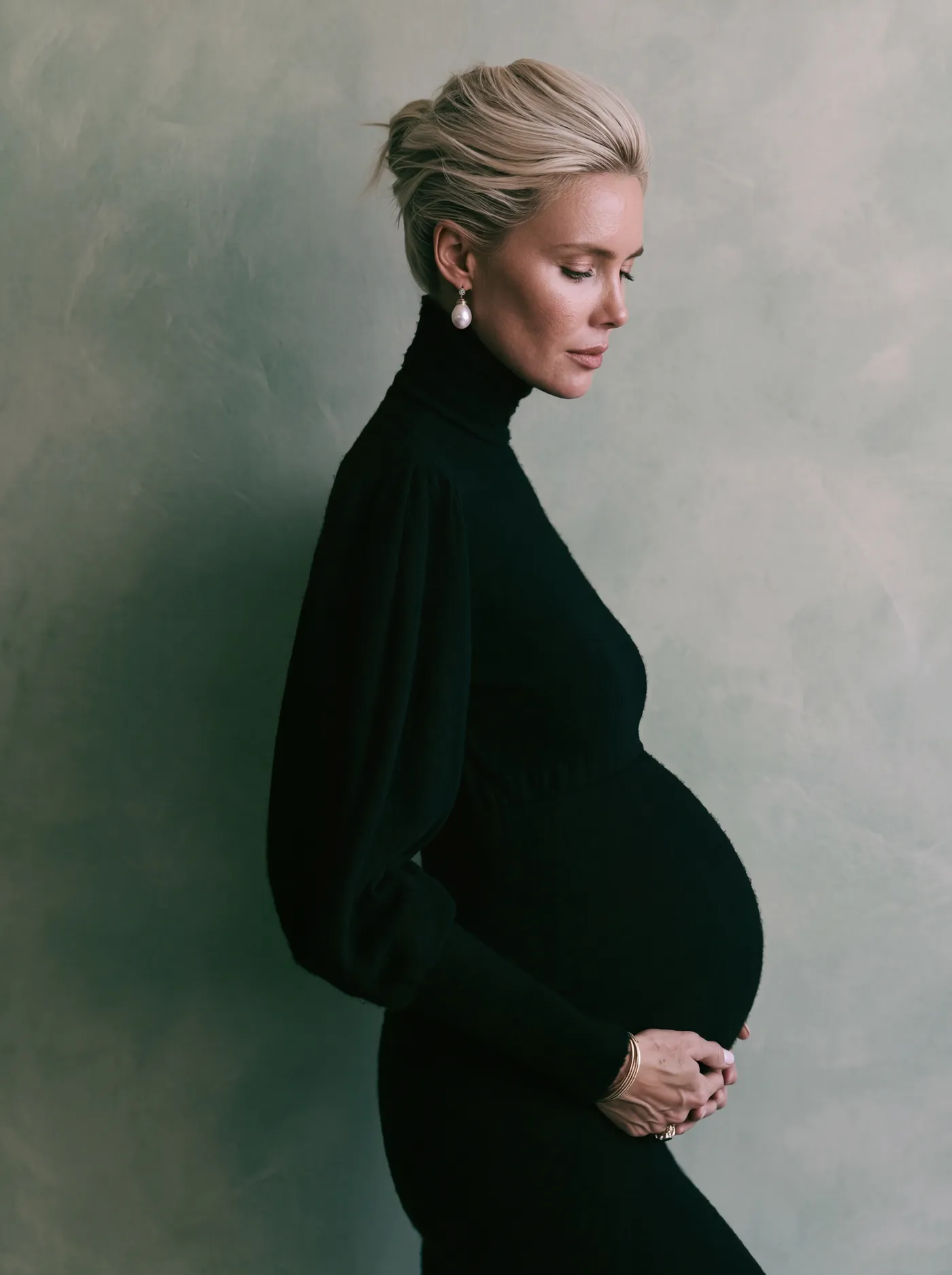 Studio maternity portrait in profile against a soft painted wall in Santa Monica